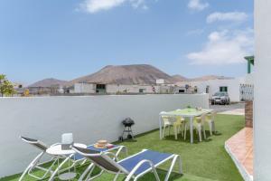 a patio with a table and chairs on the grass at Apartamento La Dehesa - Uga in Uga