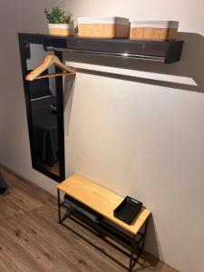 a mirror and a bench in a room at Studio 01 JD Paulistano in Ribeirão Preto
