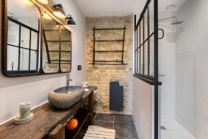 a bathroom with a stone sink and a mirror at Chambres D'hôtes La Baritaudière in La Réorthe +30 photos