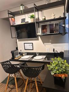 a desk with two chairs in a room at Studio 01 JD Paulistano in Ribeirão Preto