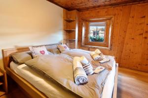 a bed in a wooden room with a window at Chalet di Mont in Valfurva