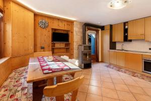 a kitchen with a wooden table and a dining room at Chalet di Mont in Valfurva