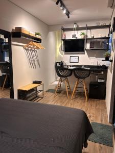 a bedroom with a bed and a desk in a room at Studio 01 JD Paulistano in Ribeirão Preto