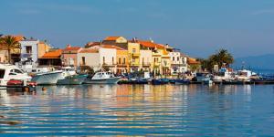 a group of boats docked in a harbor with houses at La Pineta in SantʼAntìoco