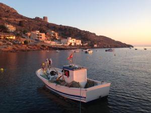 a small boat sitting in the water near a town at La Azohía Espacio en Calma in La Azohía