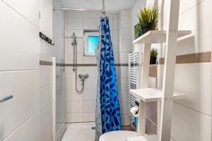 a bathroom with a blue shower curtain and a toilet at Insel Koje 1-1 in Fehmarn +18 photos