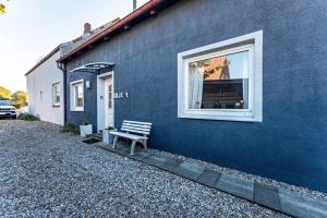 a blue building with a bench in front of a window at Insel Koje 1-1 in Fehmarn