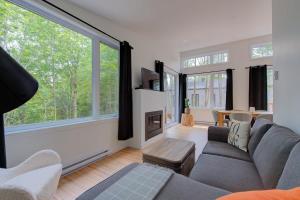 a living room with a couch and a fireplace at La Relache - Nature & Relaxation - Pet Friendly in Pont-Rouge
