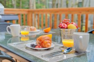a table with a breakfast of croissants and orange juice at La Relache - Nature & Relaxation - Pet Friendly in Pont-Rouge