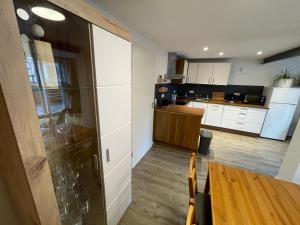 a kitchen with white cabinets and a wooden table at Ferienwohnung Happynest in Jena +26 photos