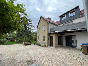 a house with a brick patio in front of it at Ferienwohnung Happynest in Jena