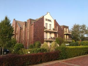 a large brick building with balconies on a street at Ferienhaus Jümmers - Jomtje in Horumersiel