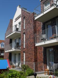 a brick building with balconies on the side of it at Ferienhaus Jümmers - Jomtje in Horumersiel