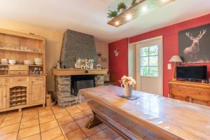 a living room with a stone fireplace and a wooden table at Gite Dans Grange Foraine - Baou in Artalens-Souin