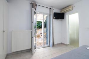 a bedroom with a sliding glass door to a balcony at Kiki's Apartments in Barbati