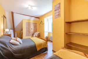 a bedroom with yellow walls and a bed with pillows at Gite Dans Grange Foraine - Baou in Artalens-Souin
