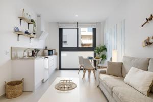 a white living room with a couch and a table at Apartamento Blue Wave 1 10 in Tarifa