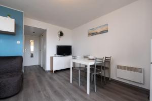 a living room with a white table and chairs at Le Sailing,parking, proche plage in Arzon