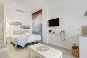a white room with a bed and a table at Apartamento Blue Wave 1 10 in Tarifa
