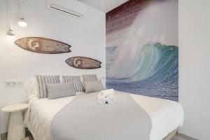 a bedroom with a bed with a large painting on the wall at Apartamento Blue Wave 1 10 in Tarifa +17 photos