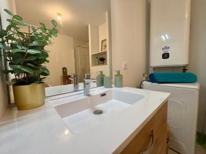 a white sink in a bathroom with a plant at Le Carnoët in Clohars-Carnoët +30 photos