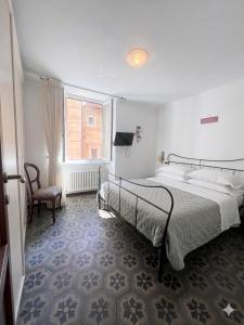 a bedroom with a bed and a chair and a window at Casa di Mà Varazze in Varazze
