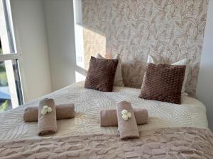 a white bed with two pillows and flowers on it at Le Carnoët in Clohars-Carnoët