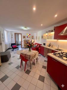 a kitchen and living room with a table with flowers on it at Casa di Mà Varazze in Varazze