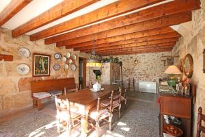 a dining room with a wooden table and a fireplace at S'hort des Cura in Islas Baleares