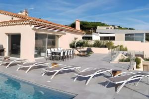 a patio with white chairs and a swimming pool at Villa Baraka in Sainte-Maxime
