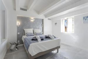 a white bedroom with a bed with blue pillows at Villa Baraka in Sainte-Maxime