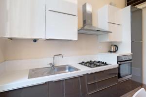 a white kitchen with a sink and a stove at Buddha, borgo dei pescatori in Cervo