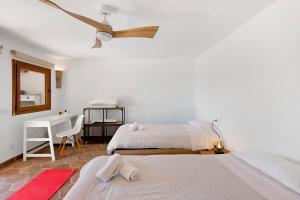 a bedroom with two beds and a ceiling fan at Praga 2 in Pals +28 photos