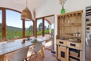 a dining room with a table and chairs and large windows at Praga 2 in Pals