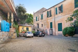 two cars parked in an alley next to buildings at Buddha, borgo dei pescatori in Cervo