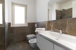a bathroom with a sink and a toilet and a window at Appartamenti Dama 1 in Bardolino +17 photos