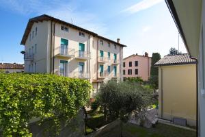 a large white building with balconies in a city at Appartamenti Dama 1 in Bardolino