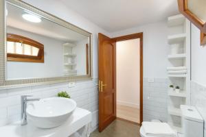 a white bathroom with a sink and a mirror at Vela in Arrecife +16 photos
