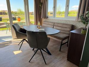 a dining room with a table and chairs at De Meerkoet Tiny House Tussen de Dijken in Driewegen +16 photos
