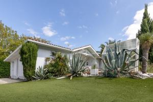a white house with palm trees and a yard at Maison De Vacances 8pers Seignosse in Seignosse