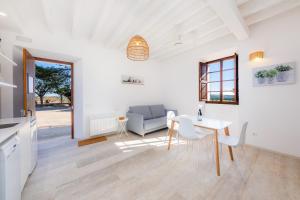 a white living room with a table and a couch at Son Crespi Vell in Manacor