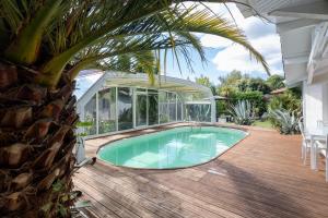 a swimming pool in a house with a glass house at Maison De Vacances 8pers Seignosse in Seignosse
