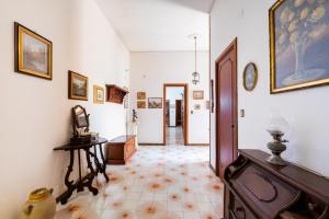 a hallway with white walls and a tile floor at Salento Home in Cursi