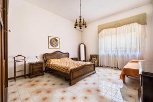 a bedroom with a bed and a table and a window at Salento Home in Cursi