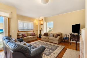 a living room with a couch and a tv at Dunas Das Marinhas in Marinhas