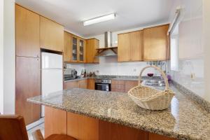 a kitchen with wooden cabinets and a counter with a basket at Dunas Das Marinhas in Marinhas
