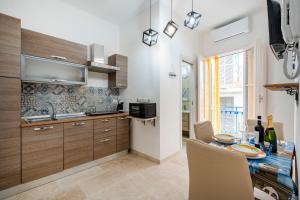 a kitchen with a table with chairs and a sink at Dimora Don Gabriele e Suite in Mola di Bari