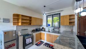 a kitchen with wooden cabinets and a counter top at Diani Hideouts 2 in Kwale