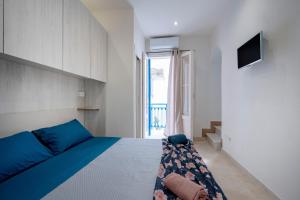 a bedroom with a blue bed and a television at Dimora Don Gabriele e Suite in Mola di Bari