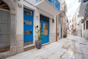 a street with blue doors in an alley at Dimora Don Gabriele e Suite in Mola di Bari